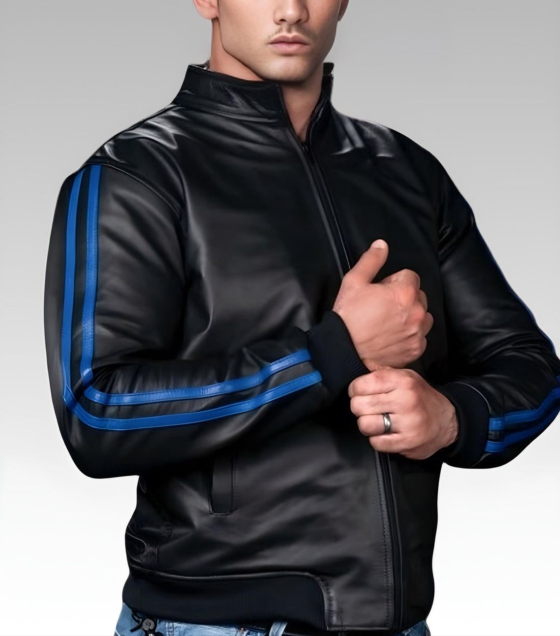 A man wearing a black leather sport jacket with red color banding on the sleeves, paired with a chain belt and blue jeans.