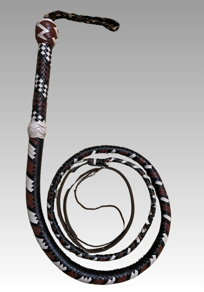 Black and white braided leather bullwhip coiled beneath its patterned handle