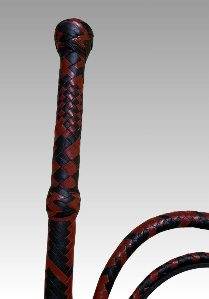 Close view of the red and black braided bullwhip handle and rounded end