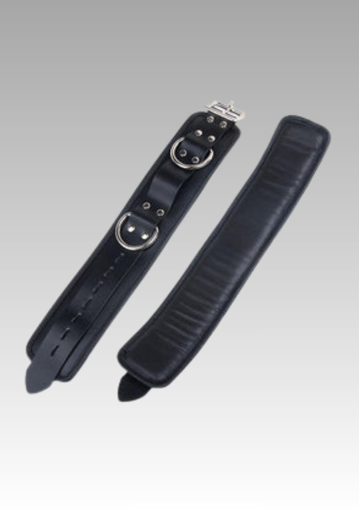 Black leather strap with metal buckles on a gray background