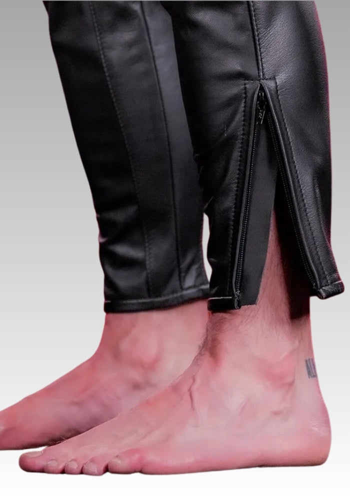Close-up of black leather pants with a gray background
