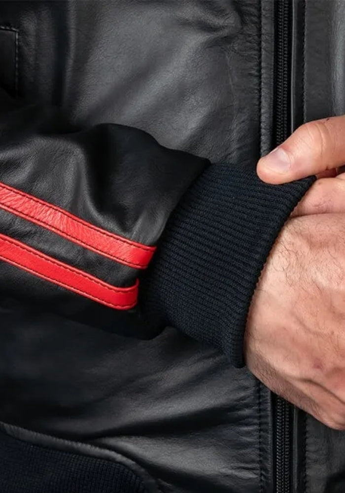 Close-up of a black leather sport jacket sleeve with red trim and ribbed cuff