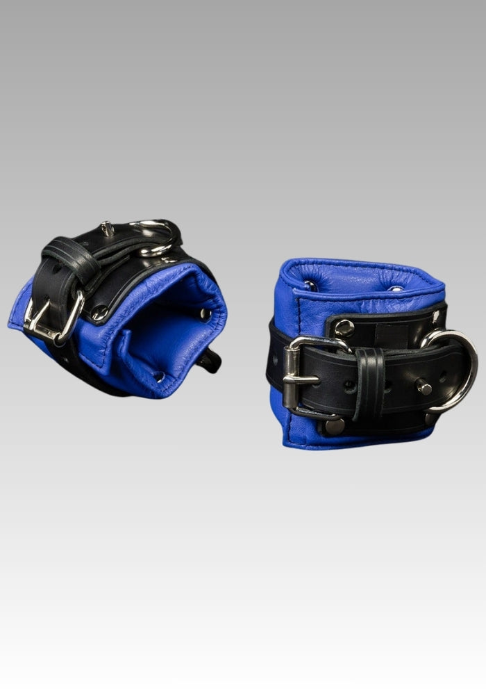 Pair of black leather wrist cuffs with blue padded lining and metal buckles