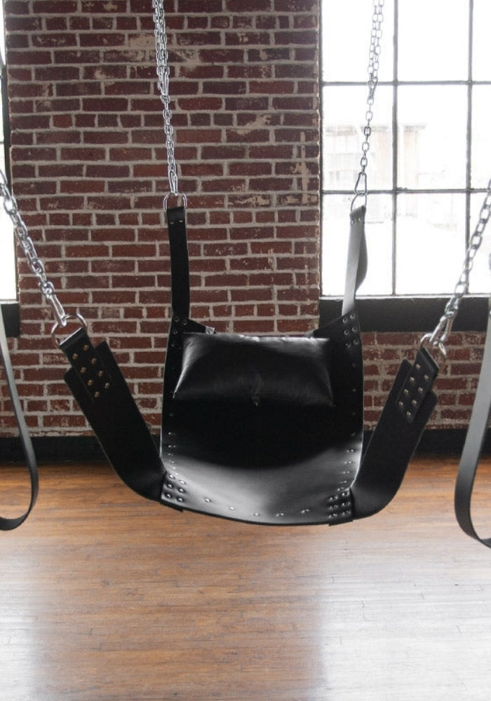 Deluxe Solid leather sling bed and pillow suspended in a room setting